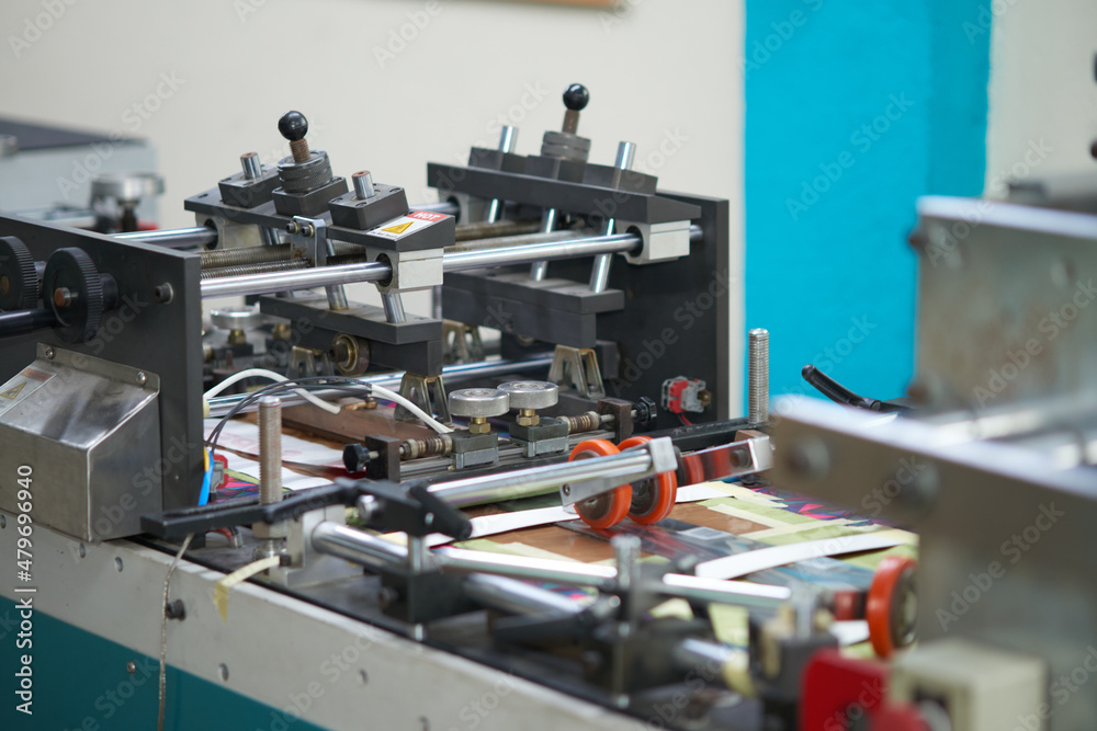 Photo of industrial print offset machine printing and processing labels for packaging products