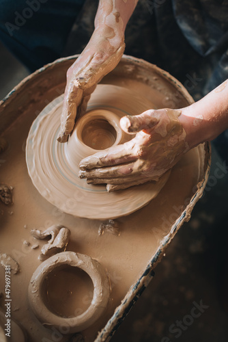 Clay modeling hands on a potter's wheel. Handmade. Ceramic tableware.