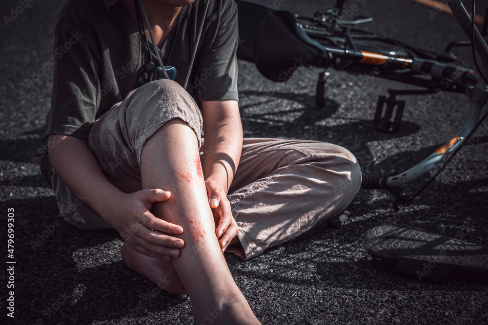 Young man suffering a bike accident at a trail , getting hurt while