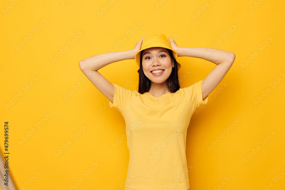 woman with Asian appearance in a yellow t-shirt and hat posing emotions Monochrome shot woman with Asian appearance in a yellow t-shirt and hat posing emotions Monochrome shot