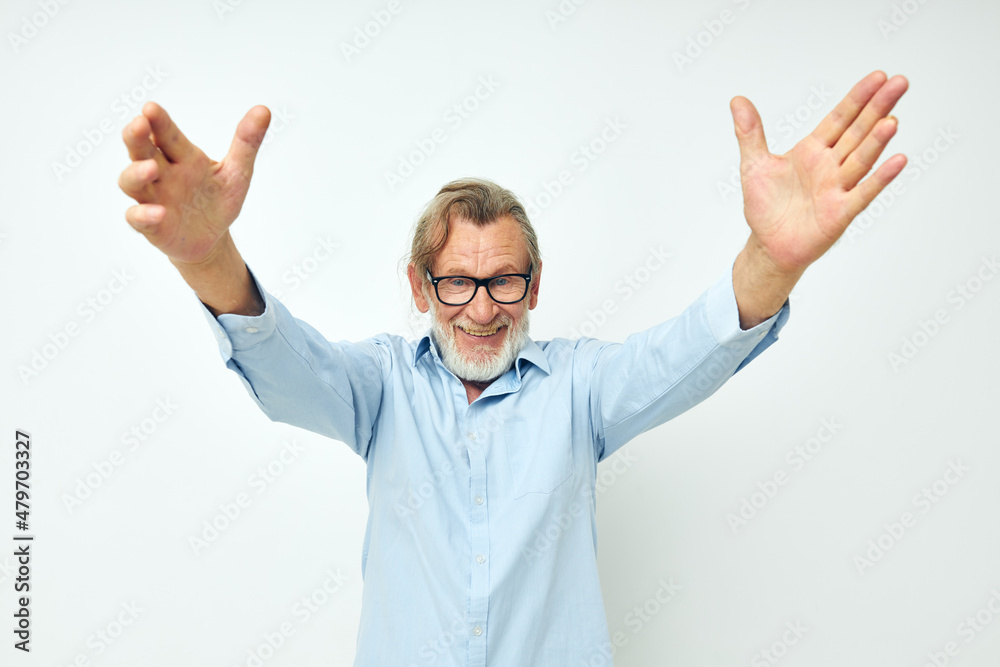 Naklejka premium old man in blue shirts gestures with his hands isolated background