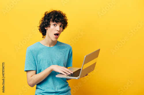 freelancer in blue t-shirts with laptop internet yellow background