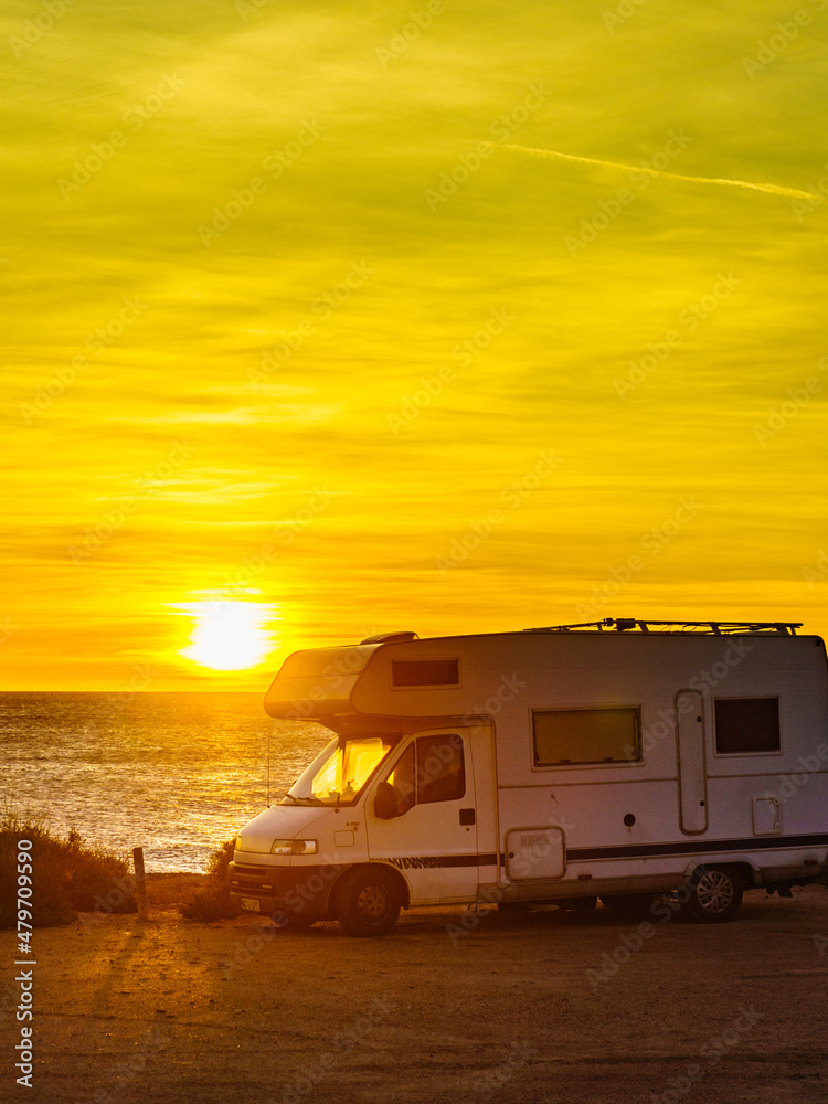 Camper car on beach at sunrise