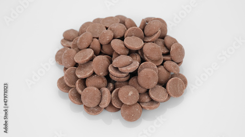 Milk chocolate callets on white background. Chocolate chips. Confectionery concept