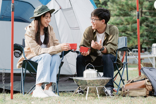 Cropped image of man and woman sitting in chairs outside the tent.