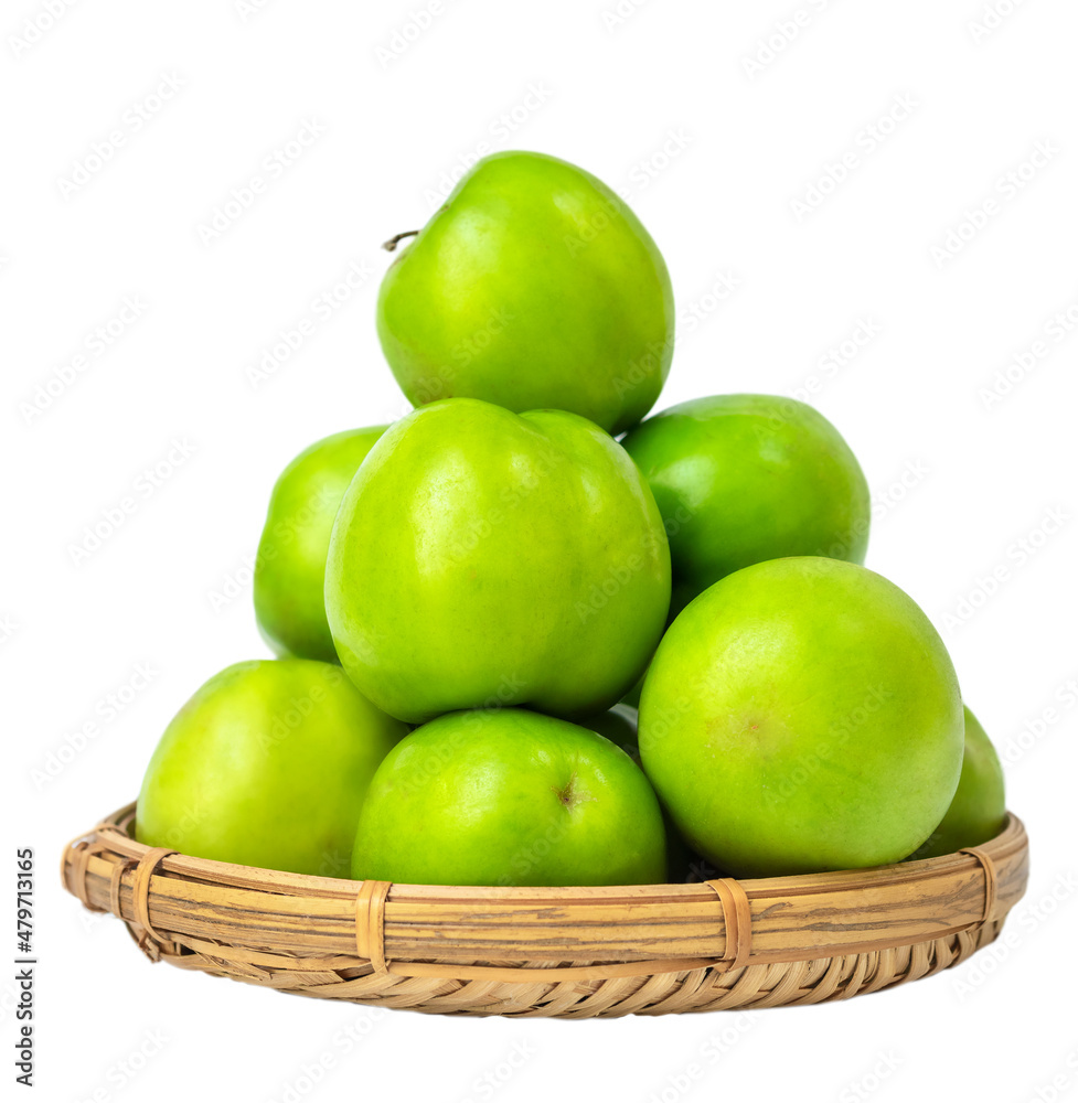 Fruit of green jojoba or plum in a straw basket isolated