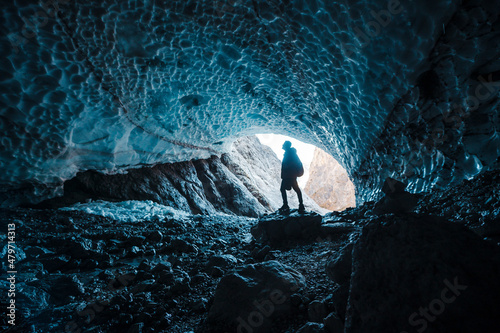 Man silhouette in crystal ice blue cave