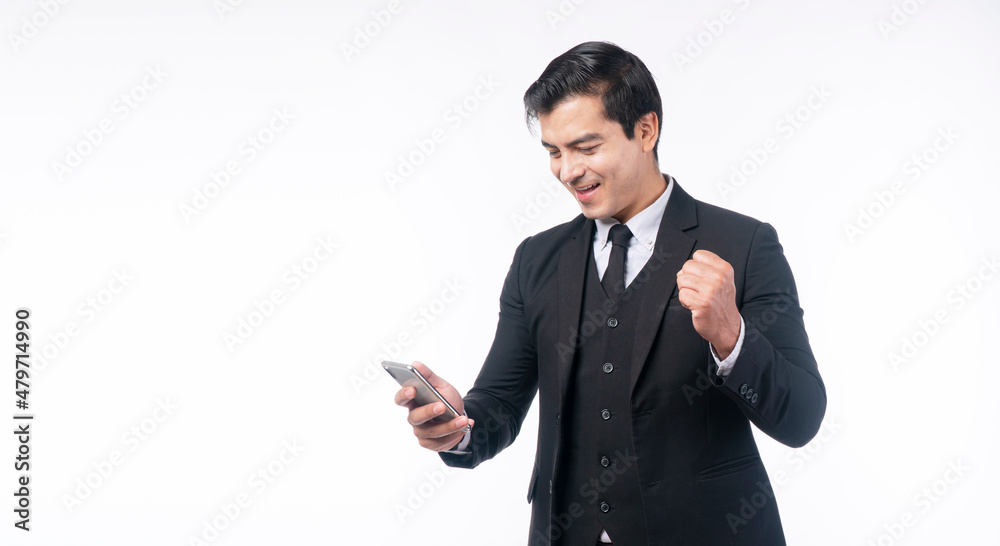Successful excited businessman looking mobile phone good news standing on white background. Excitement confident handsome man wear suit using smartphone rejoices news with copy space over isolated. Successful excited businessman looking mobile phone good news standing on white background. Excitement confident handsome man wear suit using smartphone rejoices news with copy space over isolated.
