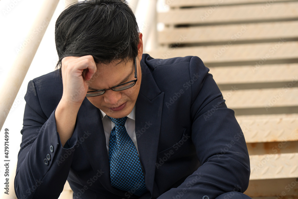 Bankruptcy layoff Asian businessman stress headache sitting on stairs step. Failed sad unemployed pain anxiety asia people man jobless worried problem economic sitting outdoor. Person failure concept.