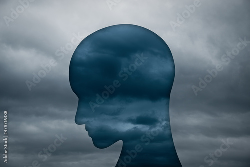 Mental depression and negative emotion concept. Person head silhouette and cloudy weather.