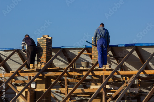 Villagers working together to build a house rooftop
