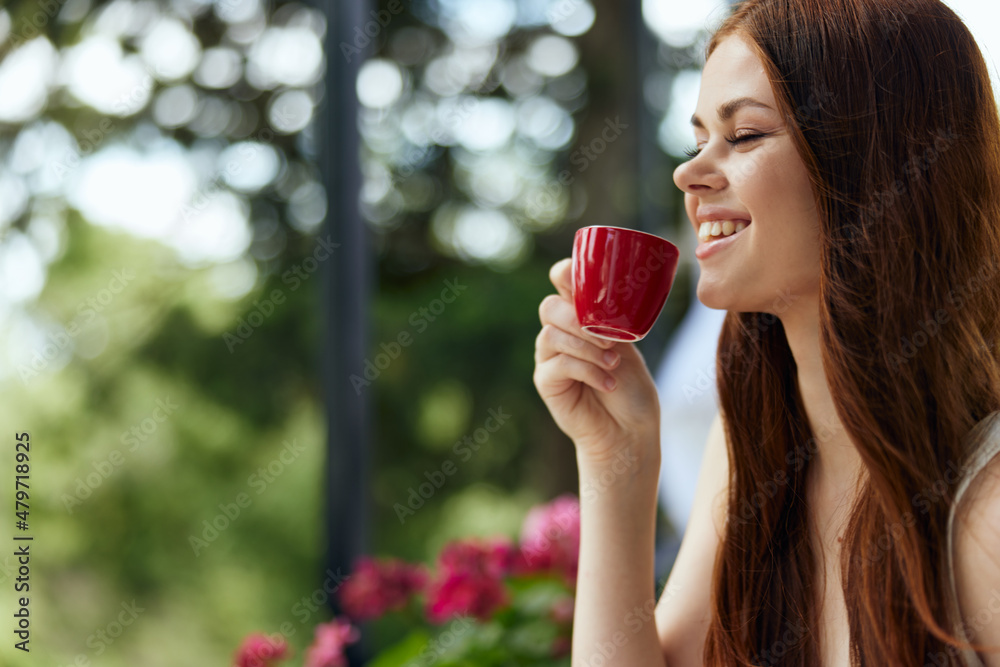 Portrait of young beautiful woman in a white dress drinks coffee outdoors in a cafe Relaxation concept