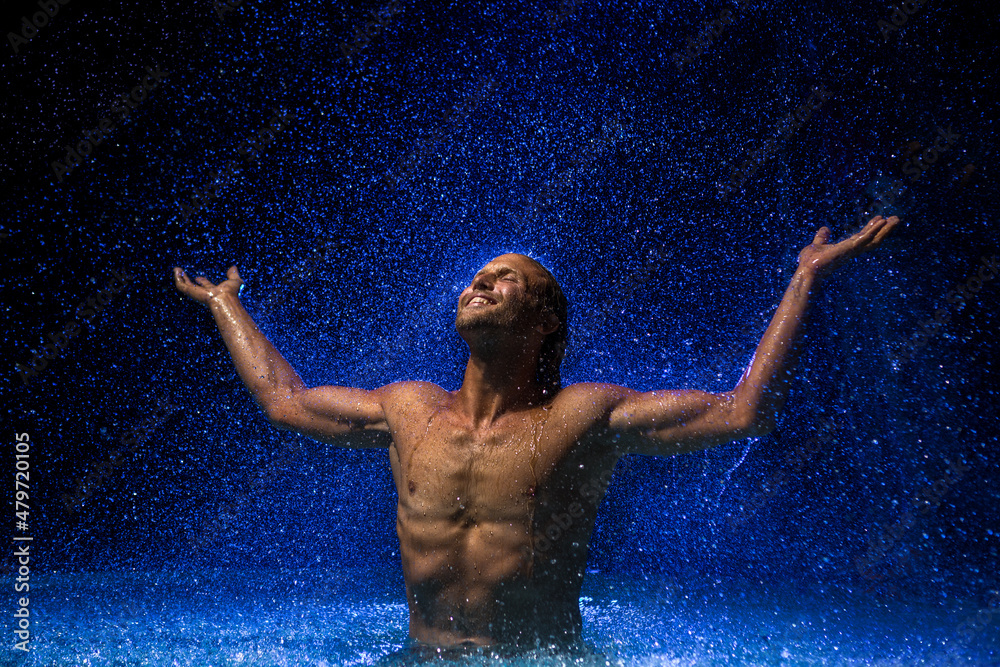 Obraz premium Muscular man in water under the rain