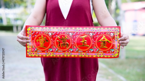 Close up red greeting card with golden auspicious Chinese characters means House Full of Money and Gold.