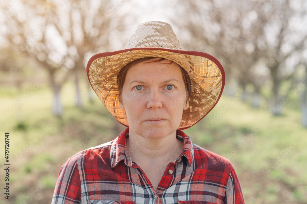 Portrait of female farmer in organic walnut orchard, sustainable farming and homegrown produce