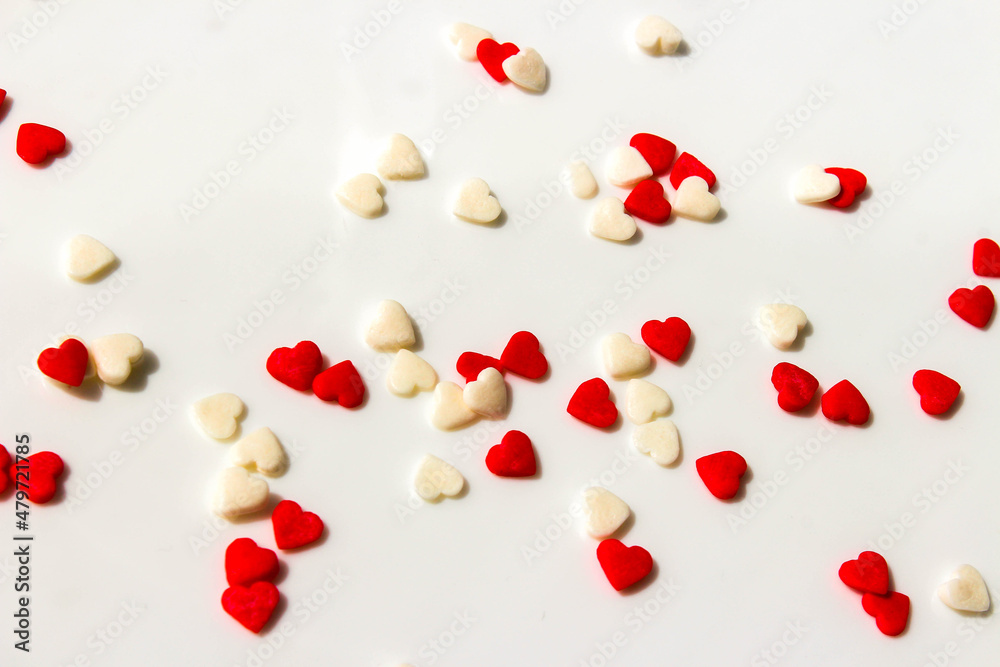 Many small white and red hearts on a white background. The concept of love and romance. Romantic background composition. Valentine's Day