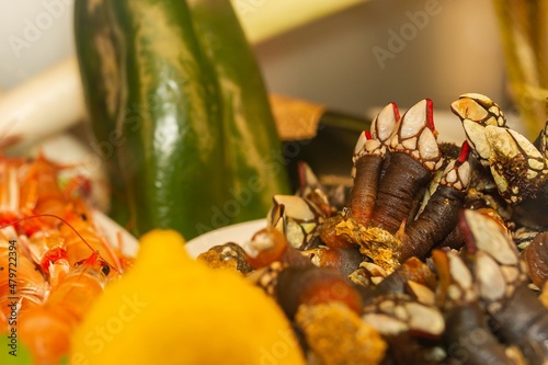 Goose neck barnacle on a plate with vegetables and other seafood, Pollicipes pollicipes, typical crustacean of Galicia (Spain), selective approach. photo