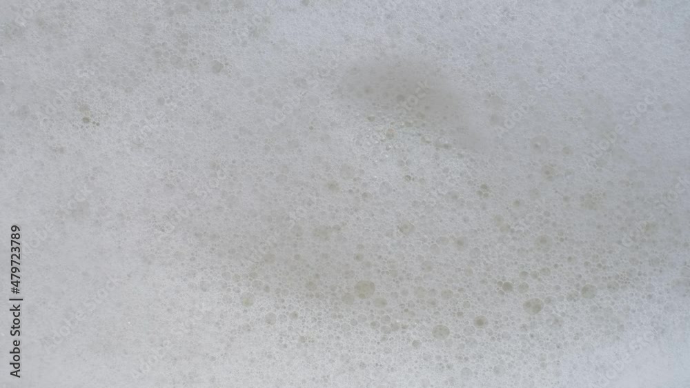 Close-up shooting soapy water. Foam abstract background. Soap foam popping isolated. Texture of white soap foam with bathtub bubbles. slow video Close-up shooting soapy water. Foam abstract background. Soap foam popping isolated. Texture of white soap foam with bathtub bubbles. slow video