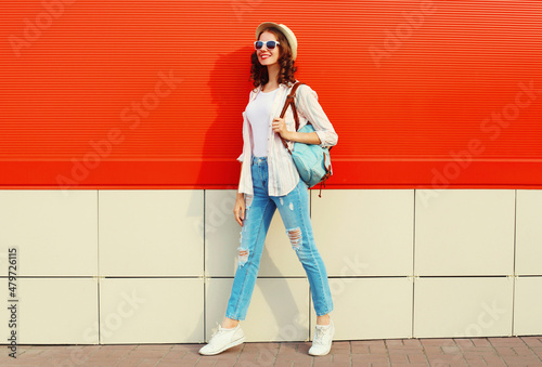Quadro em tela Young woman model posing wearing a casual, summer straw round hat on city street
