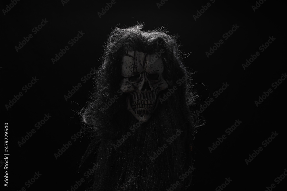 ancient face with a scary mask on a black background ancient face with a scary mask on a black background