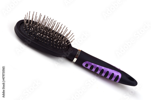 Massage comb for combing women s hair. Plastic brush with metal corners for detangling hair. On an isolated white background. Close-up.