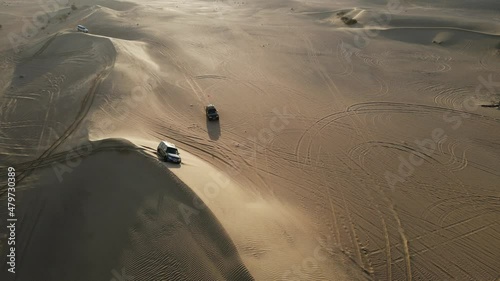 4K: Drone view of a 4x4 stuck in the sand during the desert safari in the Al Qudra desert of Dubai, United Arab Emirates photo