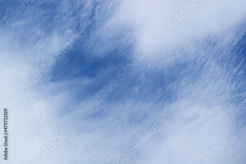Amazing white altostratus clouds spreading across vibrant blue sky photo