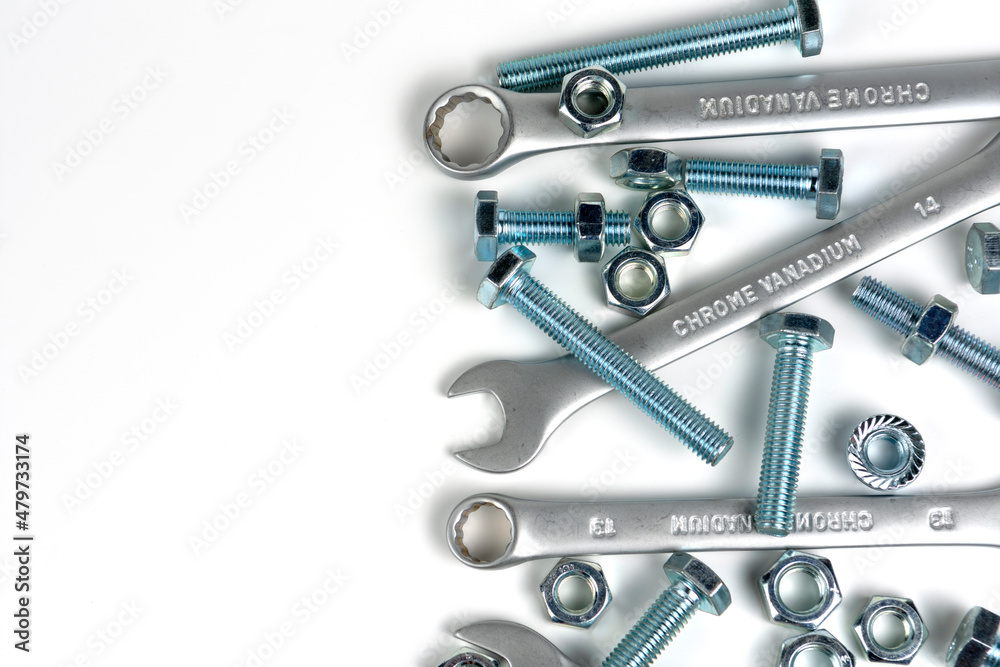 several open-end metal wrenches for working with bolts. Close-up on a white background. Silver metal fixing bolts and nuts. Copy space several open-end metal wrenches for working with bolts. Close-up on a white background. Silver metal fixing bolts and nuts. Copy space
