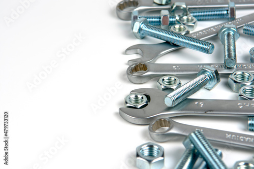 several open-end metal wrenches for working with bolts. Close-up on a white background. Silver metal fixing bolts and nuts. Copy space