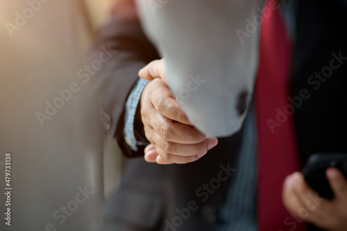 Close-up image of a businesspeople in formal suit shaking hands