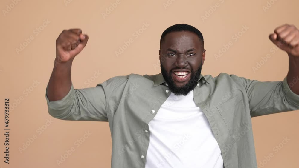 Delighted guy fist up yell yeah aim isolated pastel color background Delighted guy fist up yell yeah aim isolated pastel color background