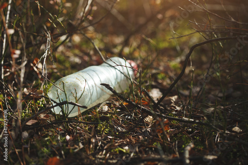 Used plastic water bottle in the forest, waste, pollution and recycling concept photo