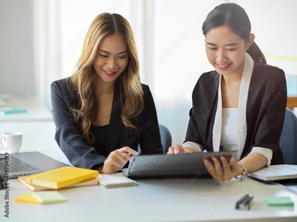 Business women looking at tablet screen and thinking a creative ideas together. Business women looking at tablet screen and thinking a creative ideas together.