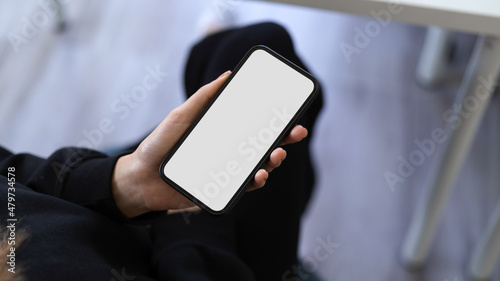 A modern smartphone blank screen mockup in a woman's hand. © bongkarn
