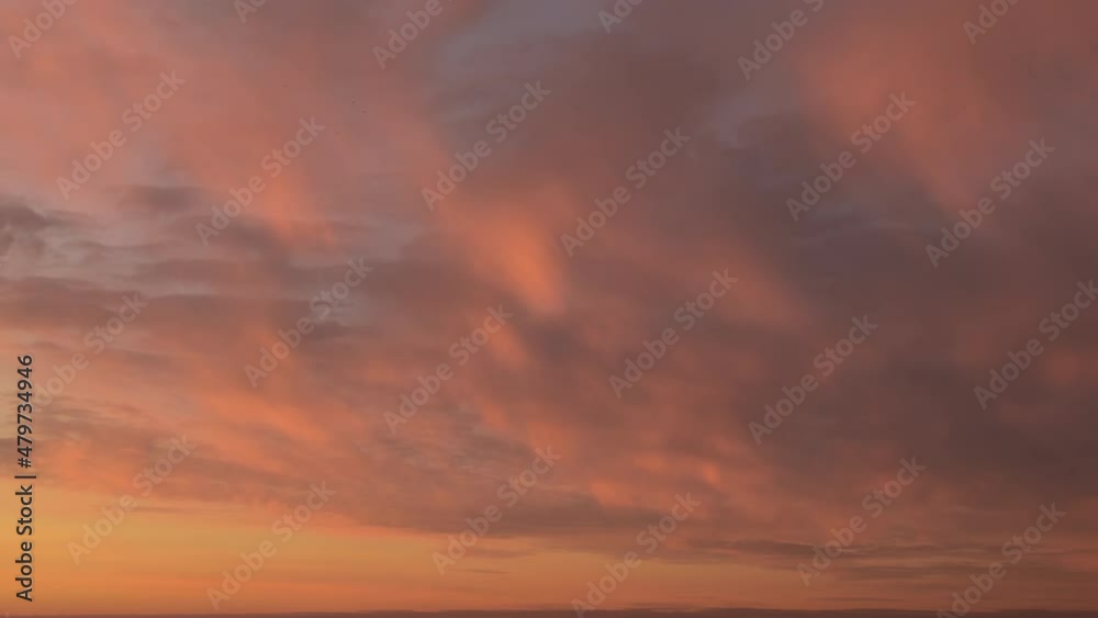Time lapse. Sunset sky with soft, fluffy, blurred pastel colored clouds moving on pink, orange, burgundy sky Time lapse. Sunset sky with soft, fluffy, blurred pastel colored clouds moving on pink, orange, burgundy sky