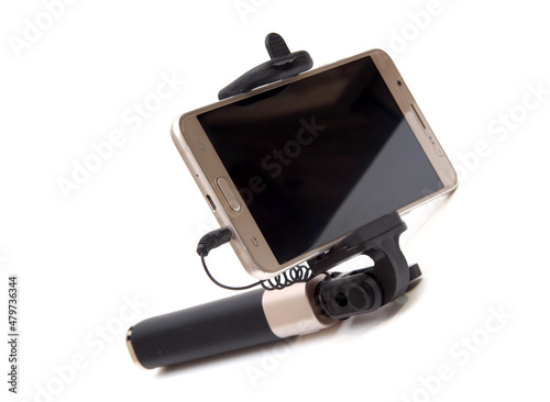 Selfie stick. and pink smartphone. material is black. On white isolated background