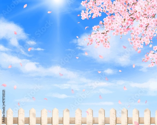 柵と美しく華やかな花びら舞い散る春の桜と青空に光差し込む雲のフレーム背景素材
