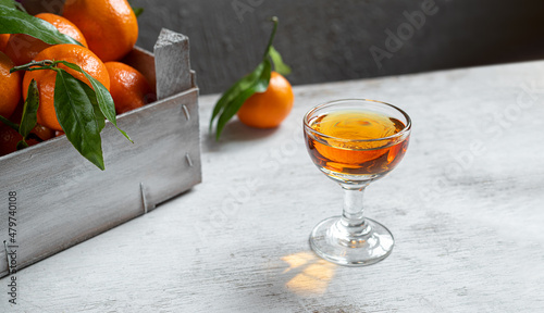 Foto A shot with tangerine liqueur on a white wooden table