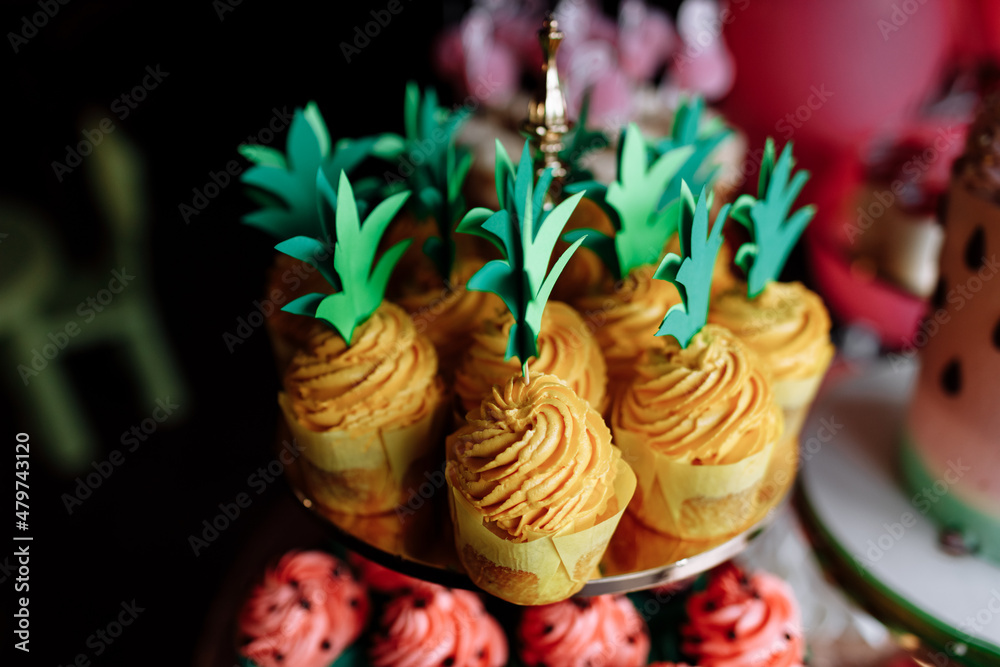 birthday exitic catering, table with modern desserts, cupcakes of pineapples, sweets with fruits. delicious candy bar at expensive birthday party. space for text. baby shower. holiday celebration