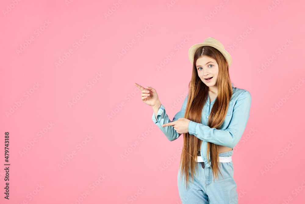 Young long hair woman shows something, point finger left at blue studio background. Girl pointing fingers left and smiling, showing advertisement. Young long hair woman shows something, point finger left at blue studio background. Girl pointing fingers left and smiling, showing advertisement.