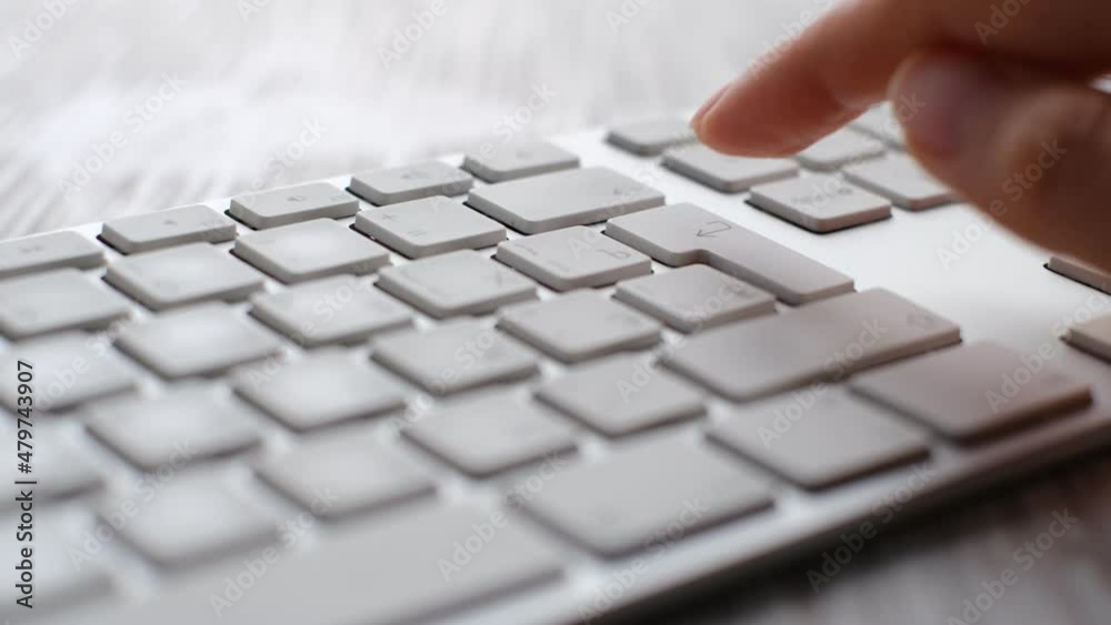 Finger pressing an enter key. Computer user hitting the enter key, up close. Confirmation, sending a message