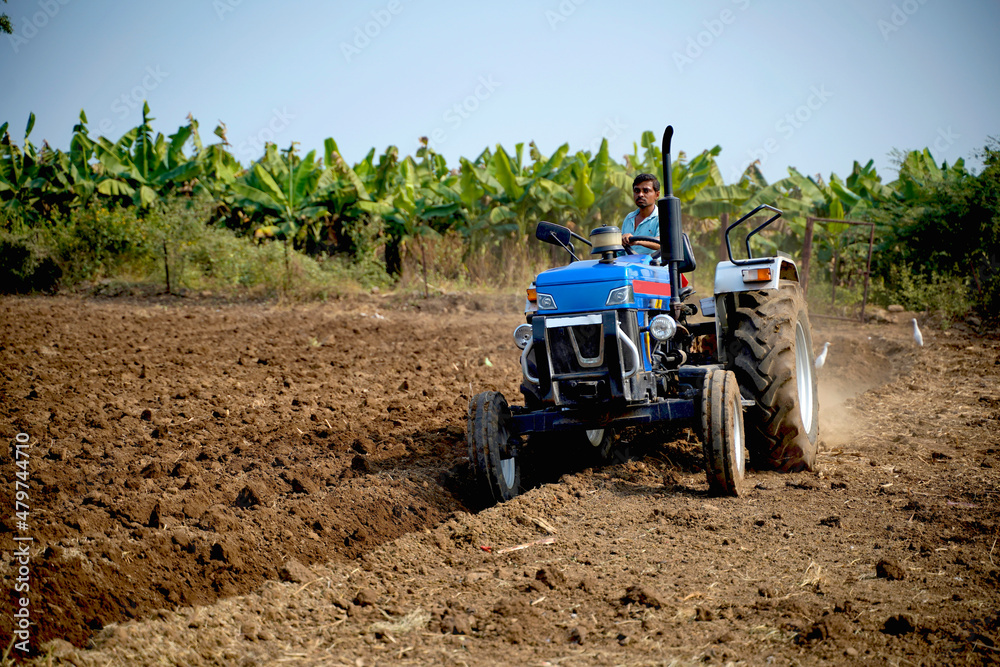 Indian farmer working with tractor in agriculture field. Indian farmer working with tractor in agriculture field.