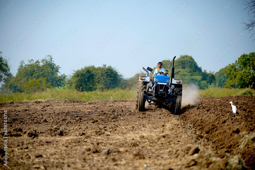 Indian farmer working with tractor in agriculture field. Indian farmer working with tractor in agriculture field.
