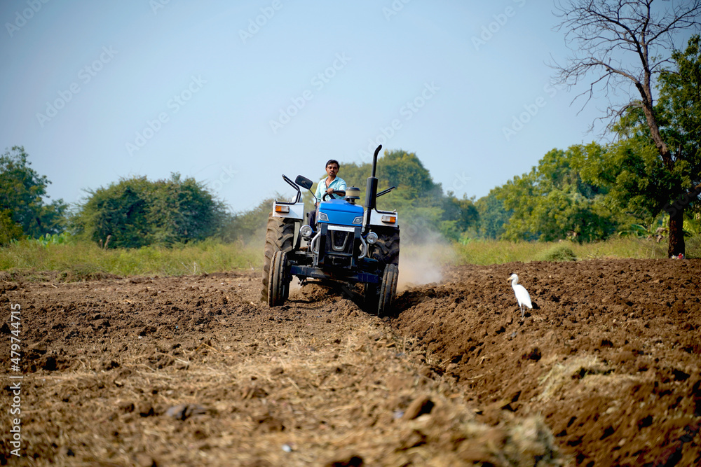Indian farmer working with tractor in agriculture field. Indian farmer working with tractor in agriculture field.