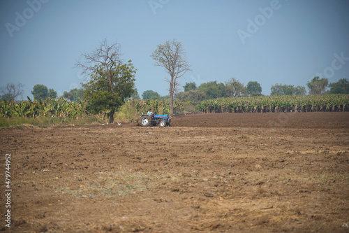 Indian farmer working with tractor in agriculture field.