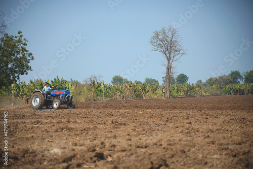 Indian farmer working with tractor in agriculture field.