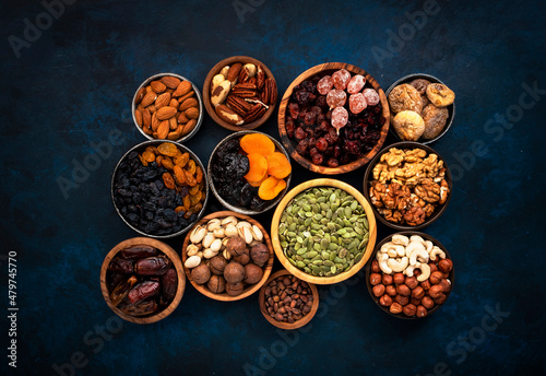 Nuts and dried fruits in assortment. Dry apricots, figs, raisins, walnuts, almonds and other. Blue table background, top view, copy space