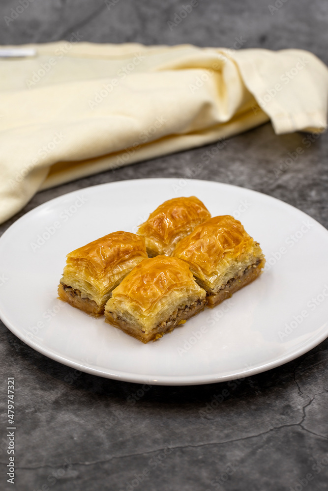 Walnut baklava on a dark background. Traditional Turkish cuisine delicacies. Close-up. Walnut baklava on a dark background. Traditional Turkish cuisine delicacies. Close-up.