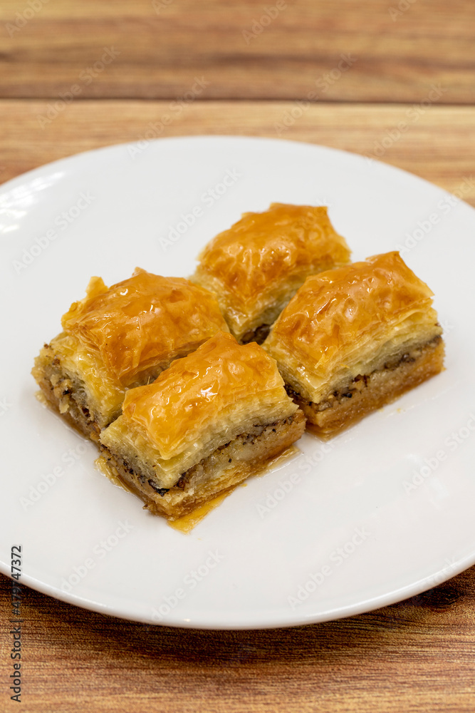 Walnut baklava on a wooden background. Traditional Turkish cuisine delicacies. Close-up. Walnut baklava on a wooden background. Traditional Turkish cuisine delicacies. Close-up.