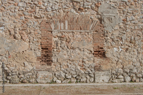 condemned and bricked up door in a brick and stone wall